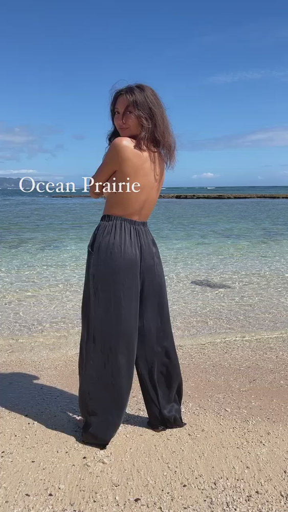 
                  
                    Load and play video in Gallery viewer, Wide-legged pants made from natural mulberry silk. Features a high-waisted cut with free flowing pant-legs. Dyed to a rich black as deep as charcoal.
                  
                